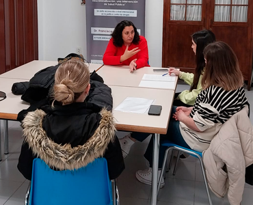 Grupo de personas recibiendo atención psicológica de una psicóloga.