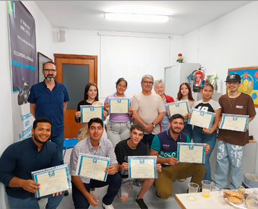 Once personas posan sonrientes sosteniendo certificados en una habitación sencilla.